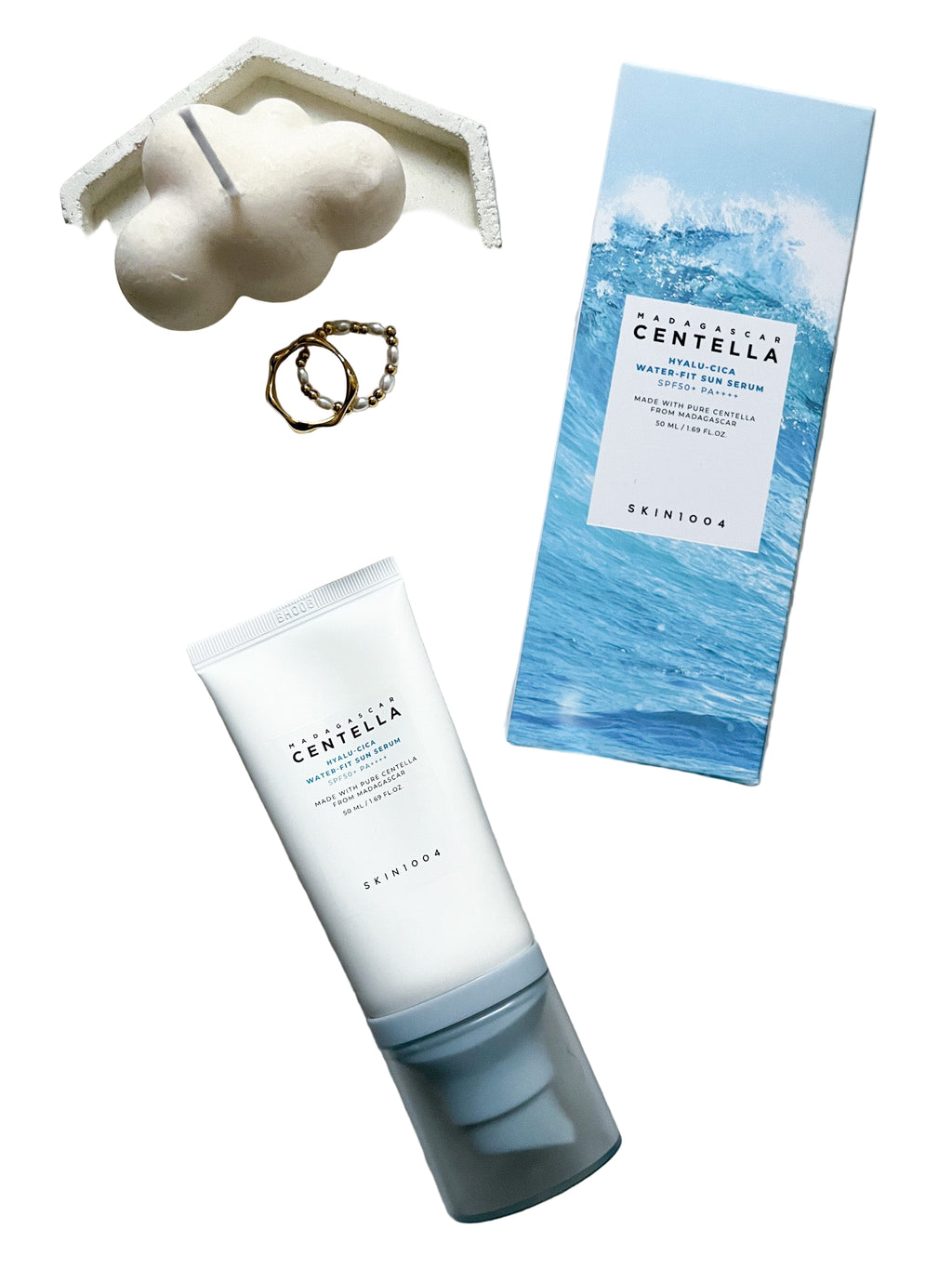 GlowTok SKIN1004 Hyalu-Cica Water-Fit Sun Serum tube, leaflet, and sponge on white background.